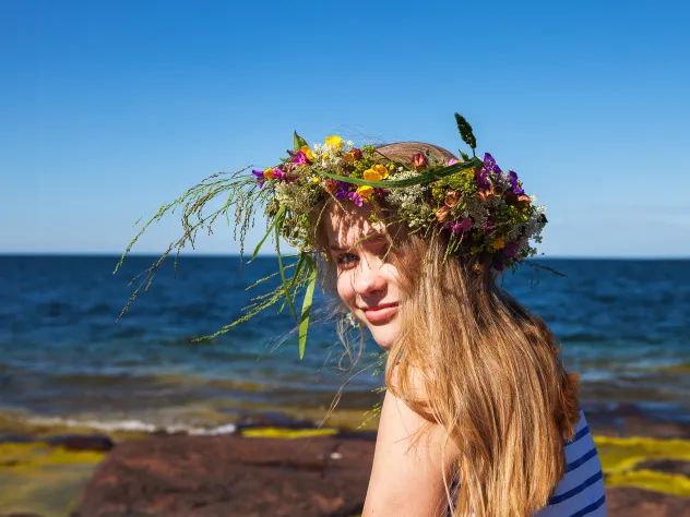 Flicka vid havet på Åland med blomkrans i håret.