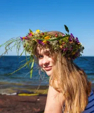 Flicka vid havet på Åland med blomkrans i håret.