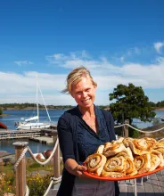 Kvinna bjuder på bullar på Rödhamn