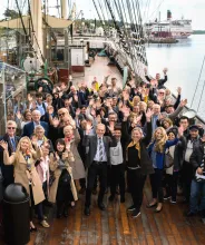 Konferensgrupp som vinkar mot kameran på fartyget Pommerns däck.