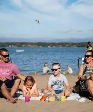 Barnfamilj på sandstranden vid Lilla Holmen.