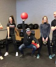 Fem personer poserar med olika träningsredskap vid Islands of Granit Crossfit.