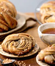 Dukat fikabord med tekopp och kanelbulle.