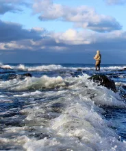Person som fiskar vid kusten på Åland.