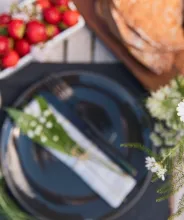Midsommardukning med nypotatis, jordgubbar och prästkragar.