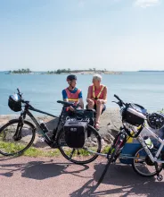 Cyklister på cykelsemester sitter och vilar på en klippa vid havet på Åland.