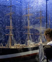 Familj tittar på fartygsmodellen av fartyget Ponape vid Ålands sjöfartsmuseum.