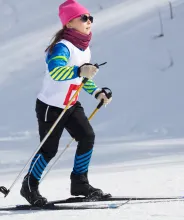 Flicka som deltar i skidtävling på längdskidor.