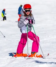 Flicka poserar i slalombacken. 