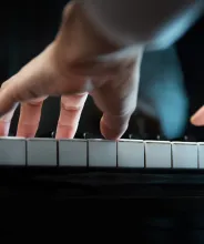 Händer som spelar på ett piano.