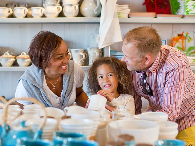 Två vuxna och ett barn tittar på keramik vid hantverkshuset SALT.