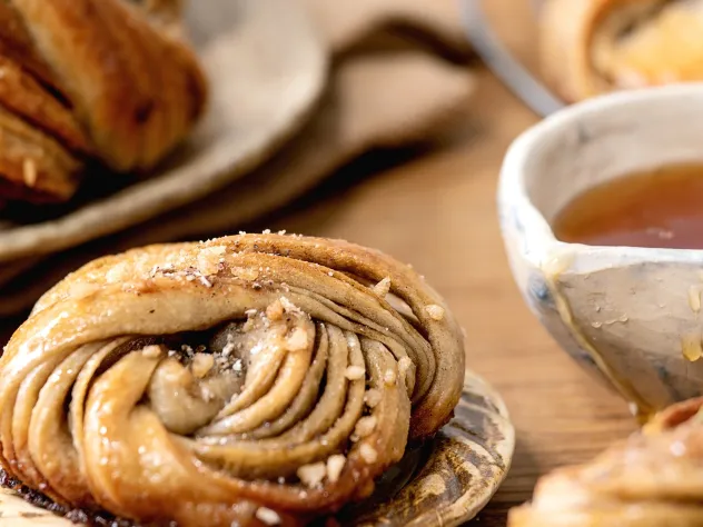 Dukat fikabord med tekopp och kanelbulle.