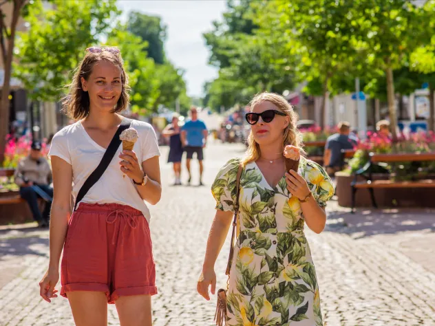 Sommarklädda kvinnor äter glass på gågatan i Mariehamn.