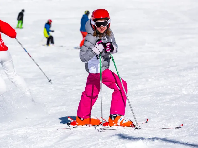 Flicka poserar i slalombacken. 