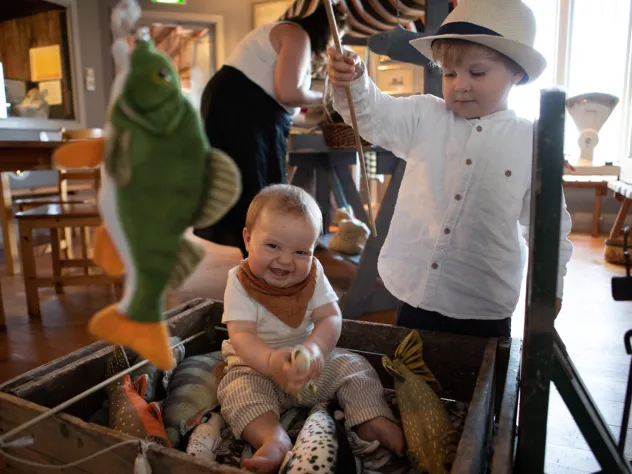 Barn som leker med leksaksfiskar i Ålands jakt- och fiskemuseum.
