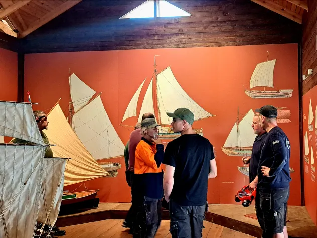 Interiör från Sjökvarterets museum med modeller och illustrationer av olika båtar.
