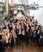 Konferensgrupp som vinkar mot kameran på fartyget Pommerns däck.