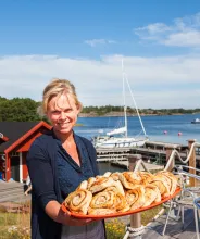Värdinnan Anette Gustafsson med ett fat nybakade bullar vid gästhamnen Rödhamn på Åland.