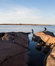Barn som hoppar på klipporna på Sälskär, Åland.