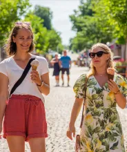 Sommarklädda kvinnor äter glass på gågatan i Mariehamn.