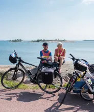 Cyklister på cykelsemester sitter och vilar på en klippa vid havet på Åland.