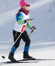 Flicka som deltar i skidtävling på längdskidor.