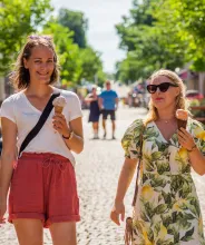 Kvinnor äter glass och promenerar på gågatan i Mariehamn.