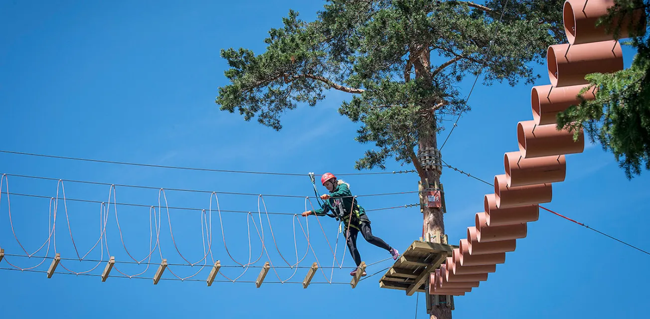 Person som klättrar på höghöjdsbanan Flow Park.