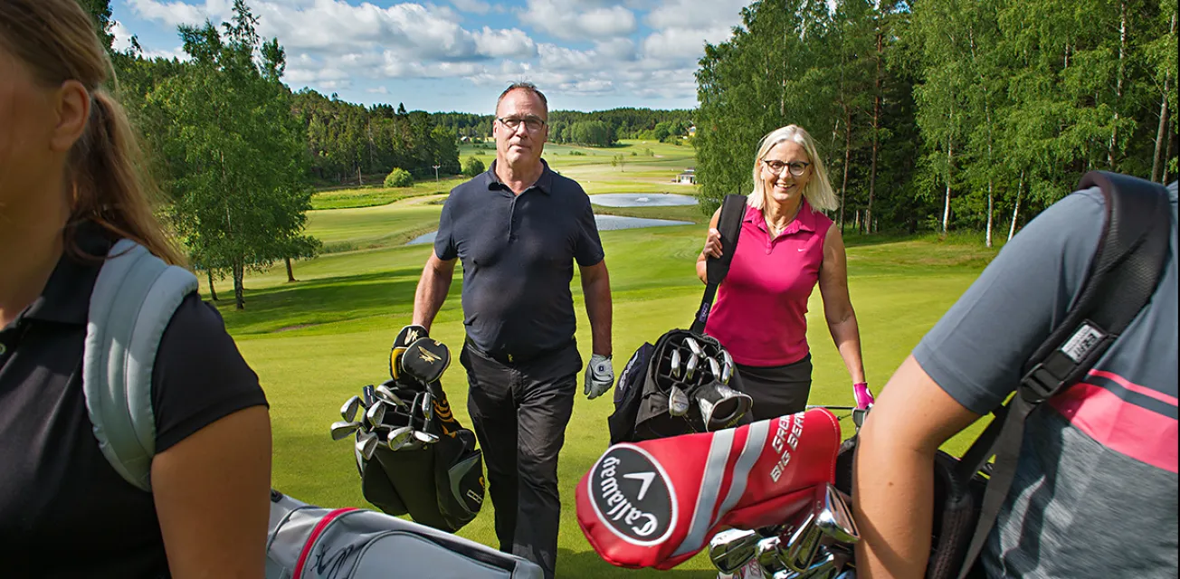 Golfspelare går mellan hålen på golfbanan i Kastelholm.