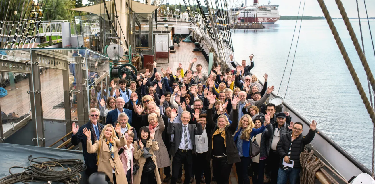 Konferensgrupp som vinkar mot kameran på fartyget Pommerns däck.