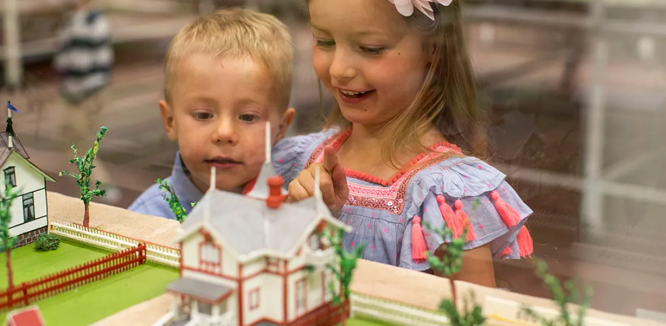 Två barn som tittar på miniatyrhusen i museet för modellstaden Mariehamn.