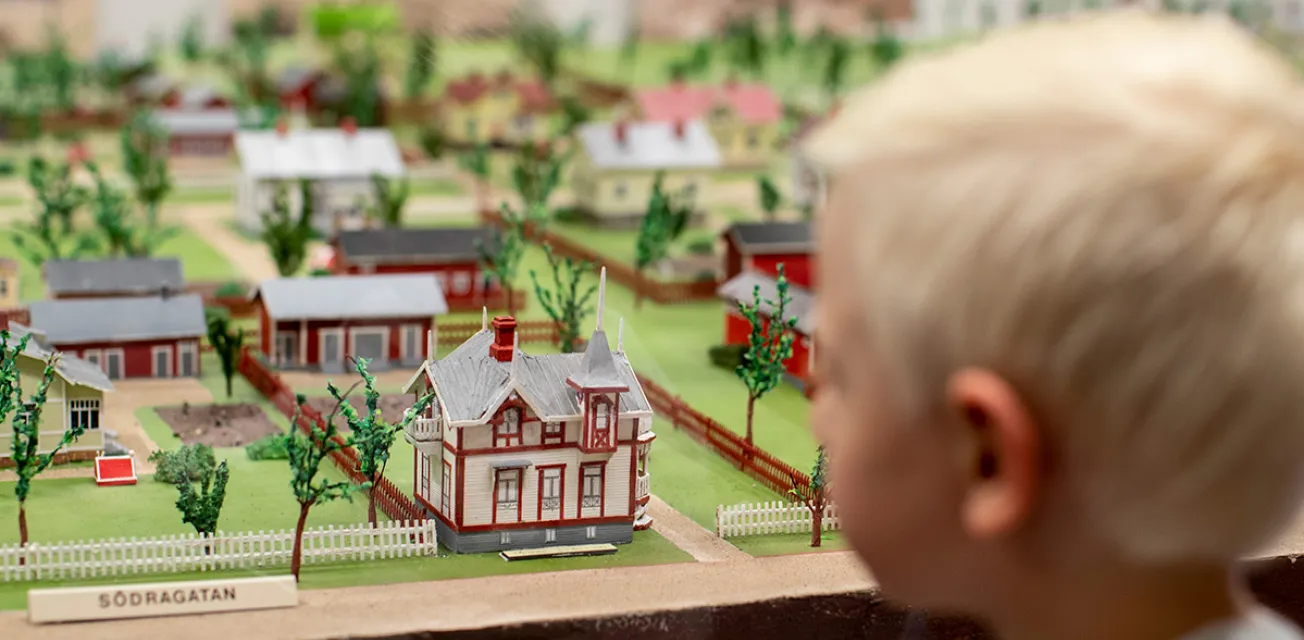 Barn som tittar på miniatyrhus vid museet Modellstaden i Mariehamn.