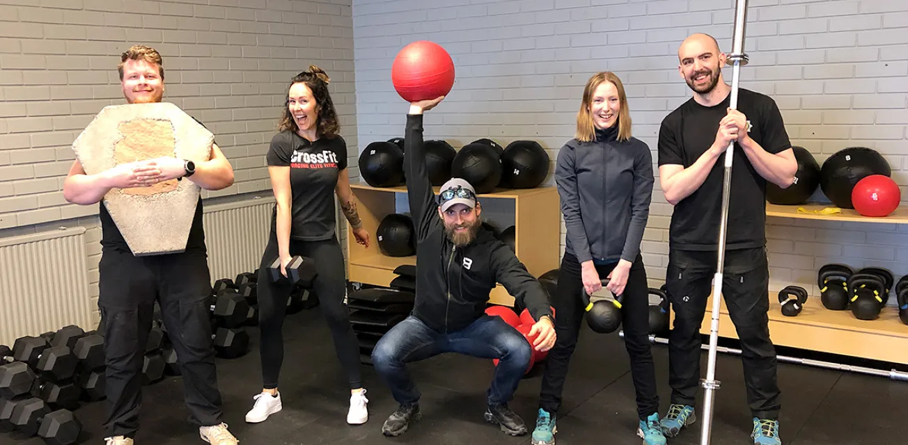 Fem personer poserar med olika träningsredskap vid Islands of Granit Crossfit.