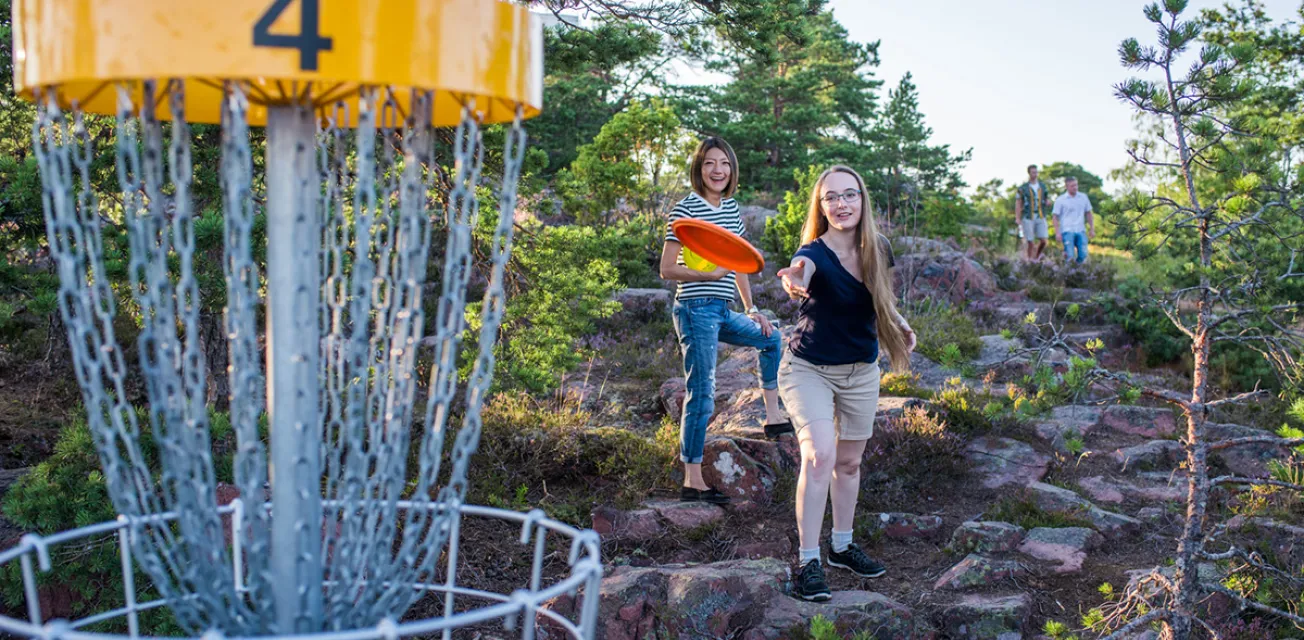 Två kvinnor kastar frisbeegolf vid Badhusparken i Mariehamn.