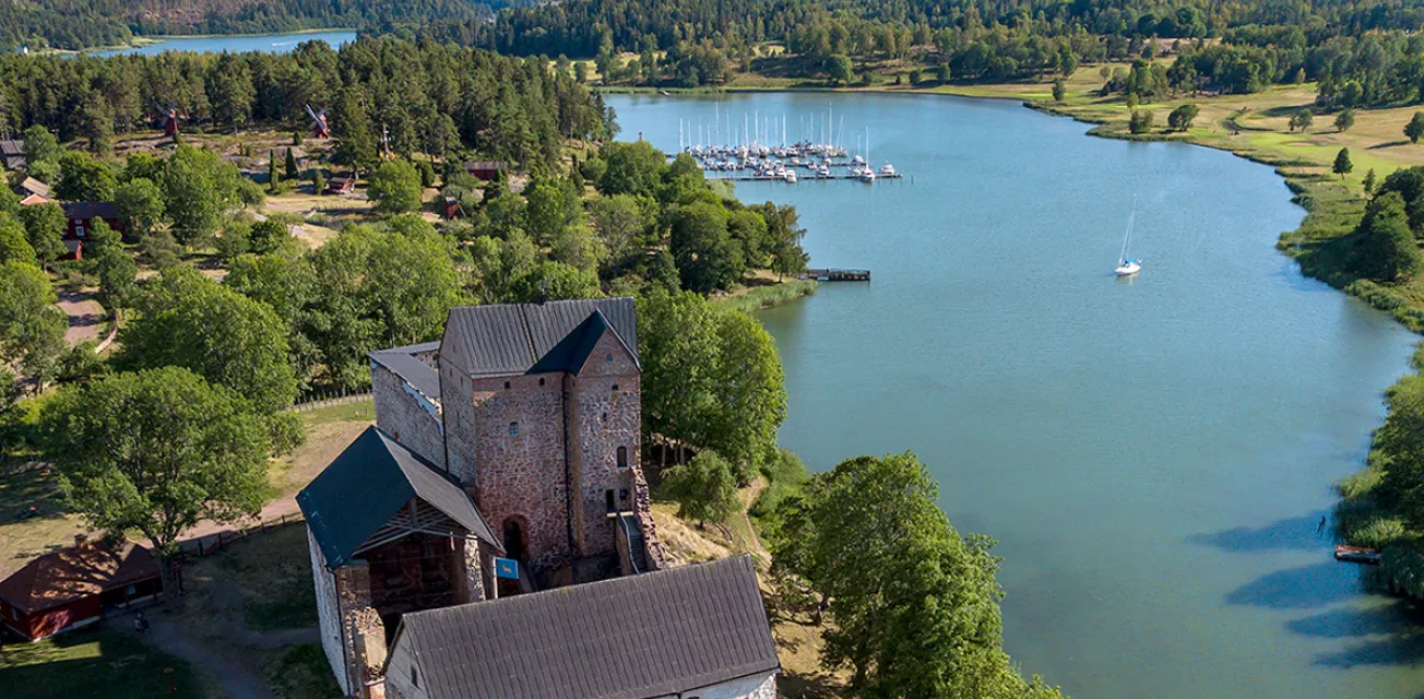 Flyfoto över Kastelholms slott med Kasteholms gästhamn i bakgrunden.