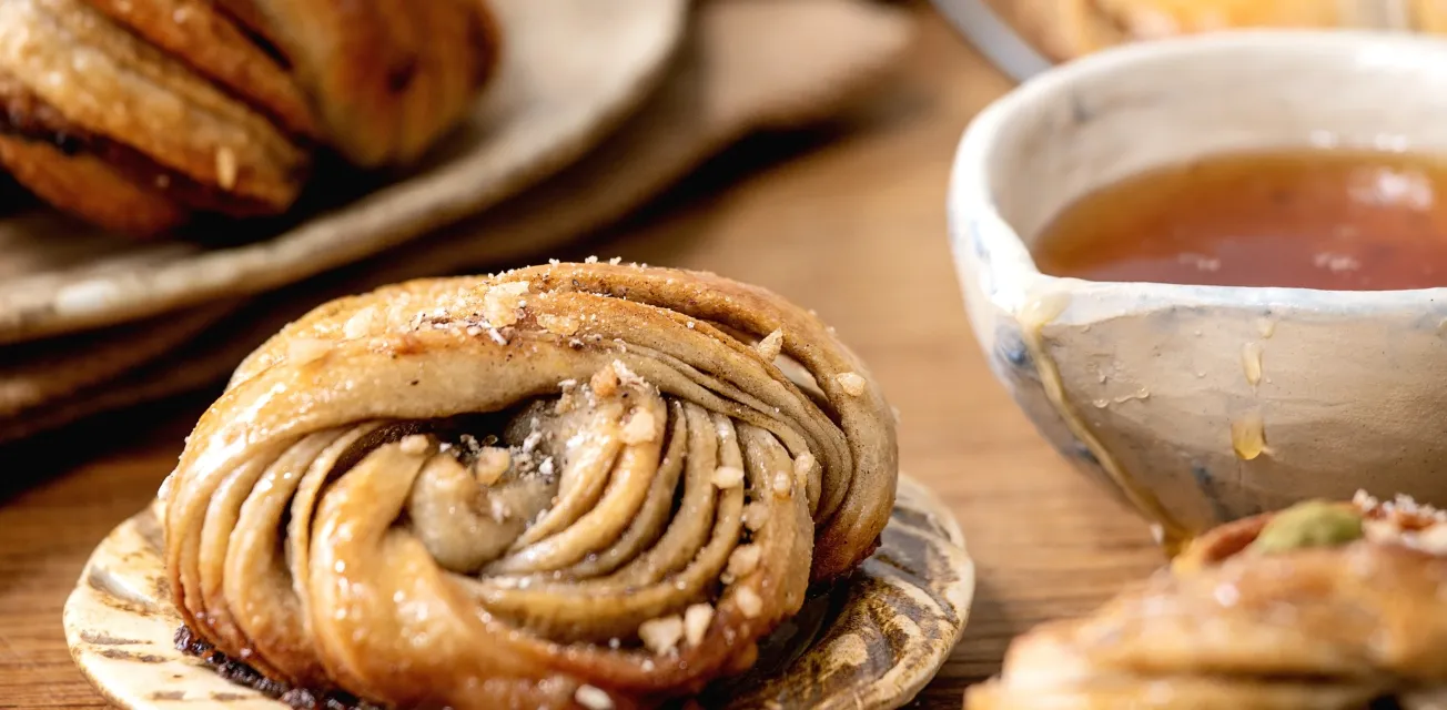 Dukat fikabord med tekopp och kanelbulle.