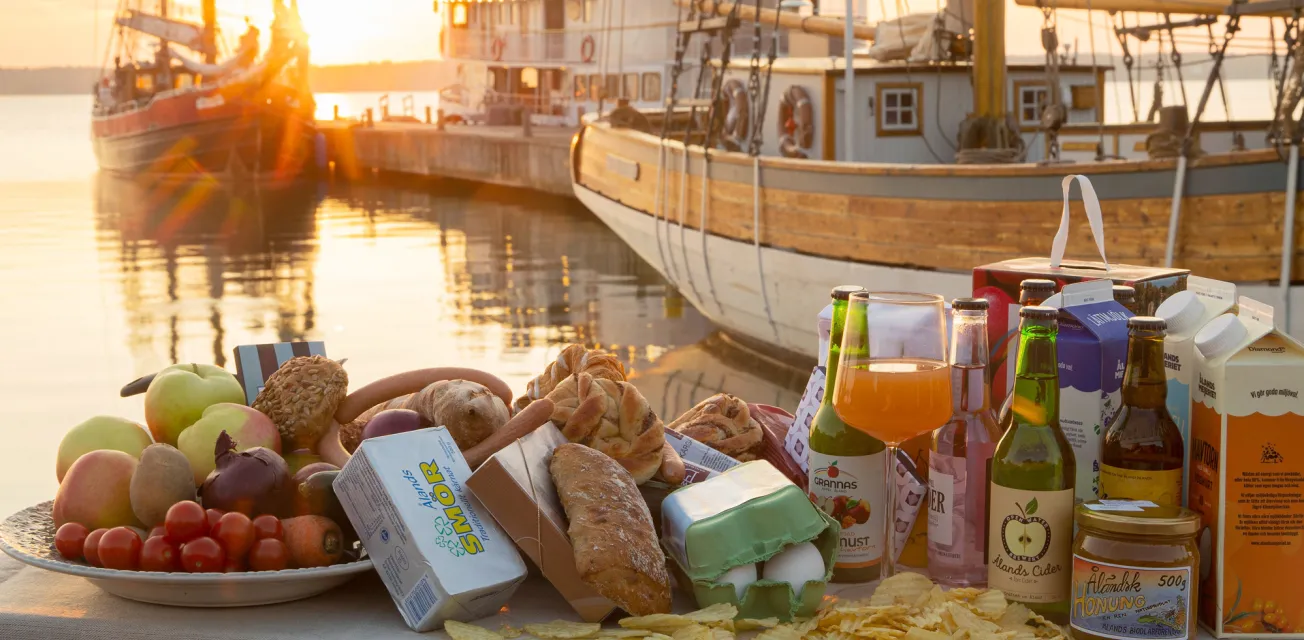 Uppdukat bord med åländska matvaror och mathantverk i soluppgången i Sjökvarteret.