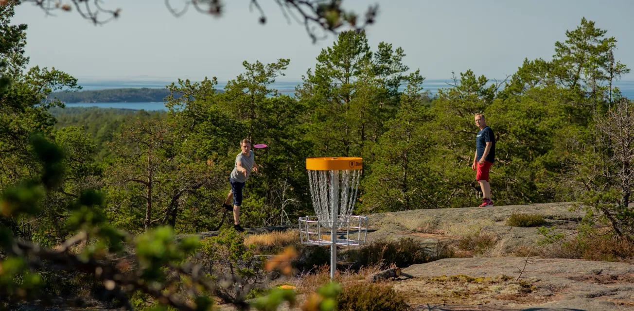 Två killar spelar discgolf på Åland