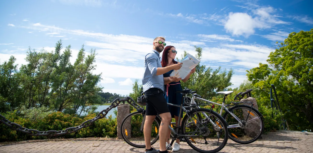 Par med cyklar som studerar cykelkarta på Åland.