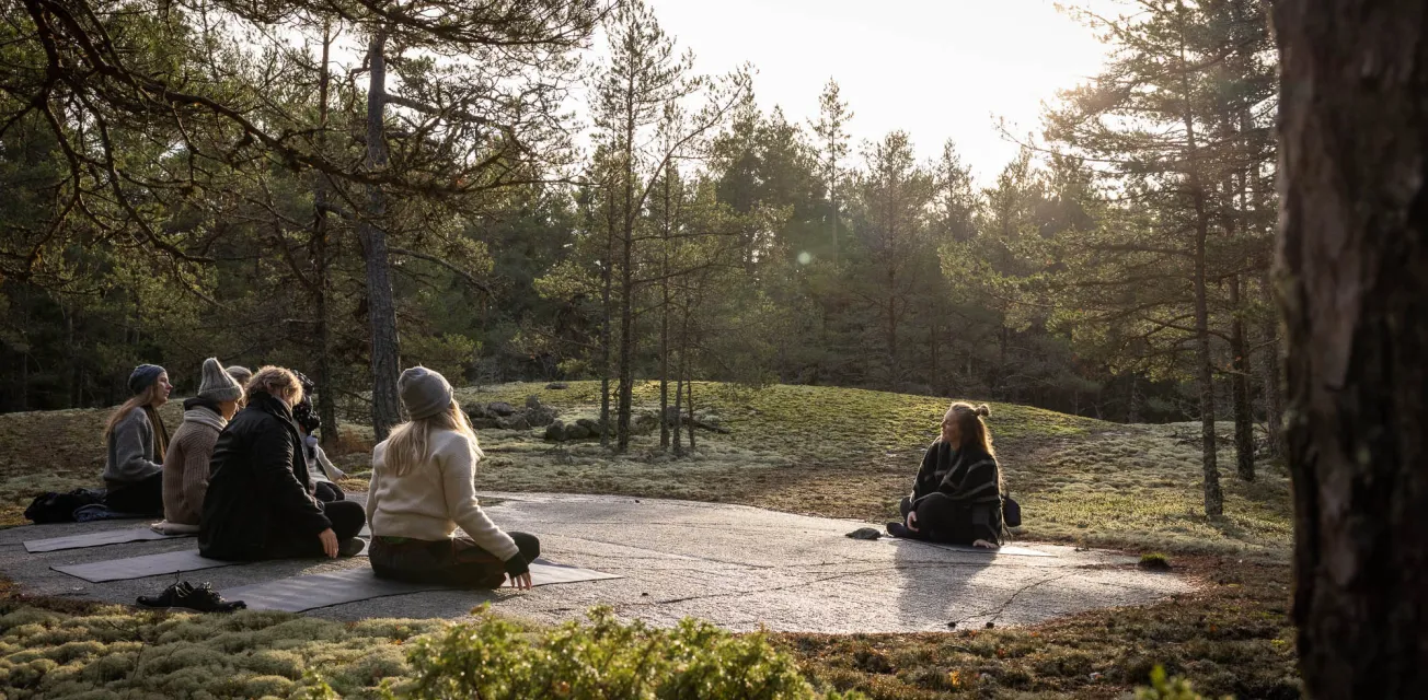 Kvinnor på skogsyoga med Caroline Henriksson i den åländska skärgårdsskogen.