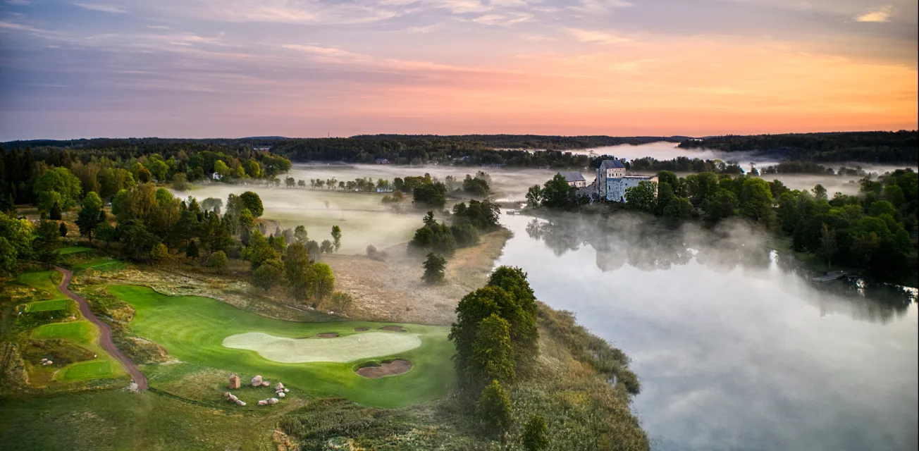 Slottsbanan vid Ålands Golfklubb med utsikt över Kastelholms slott i morgondis.
