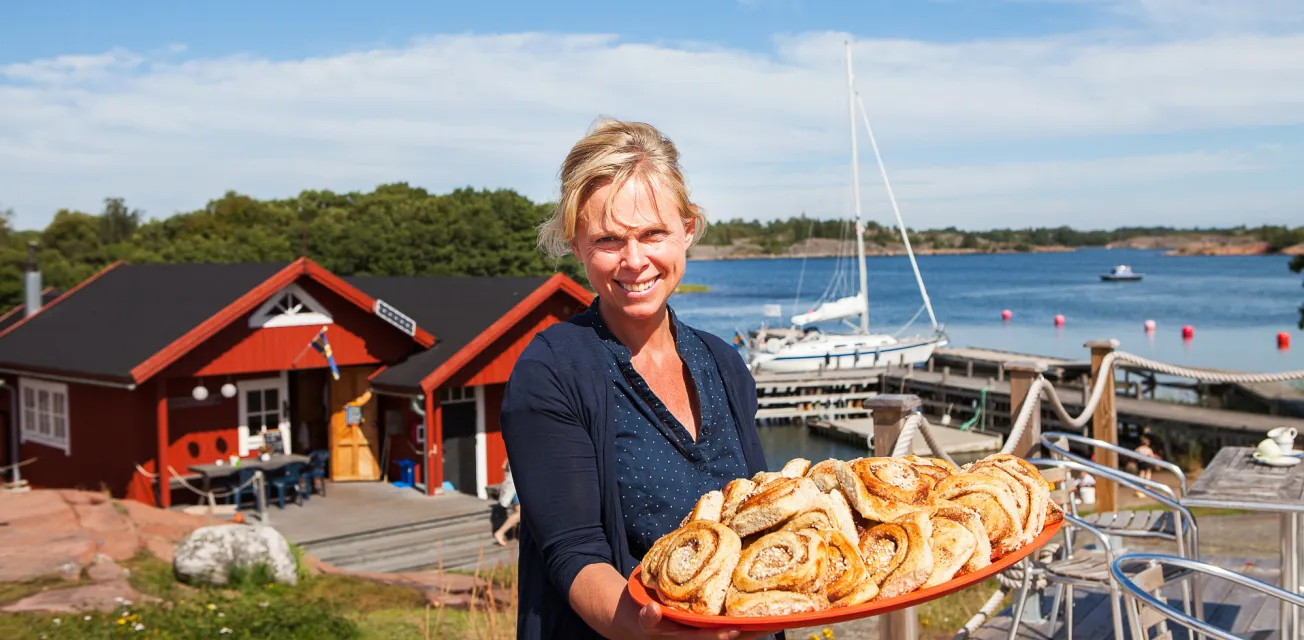 Värdinnan Anette Gustafsson med ett fat nybakade bullar vid gästhamnen Rödhamn på Åland.