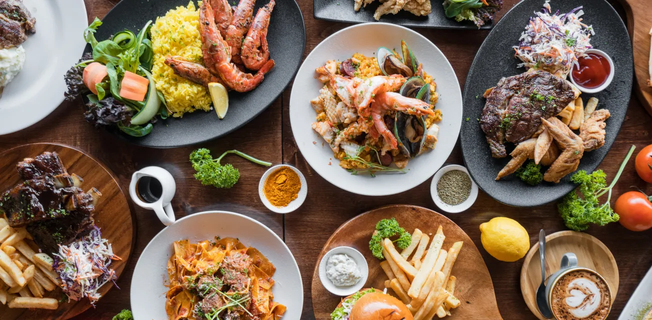Ett bord med olika restaurangrätter fotograferat från ovan.