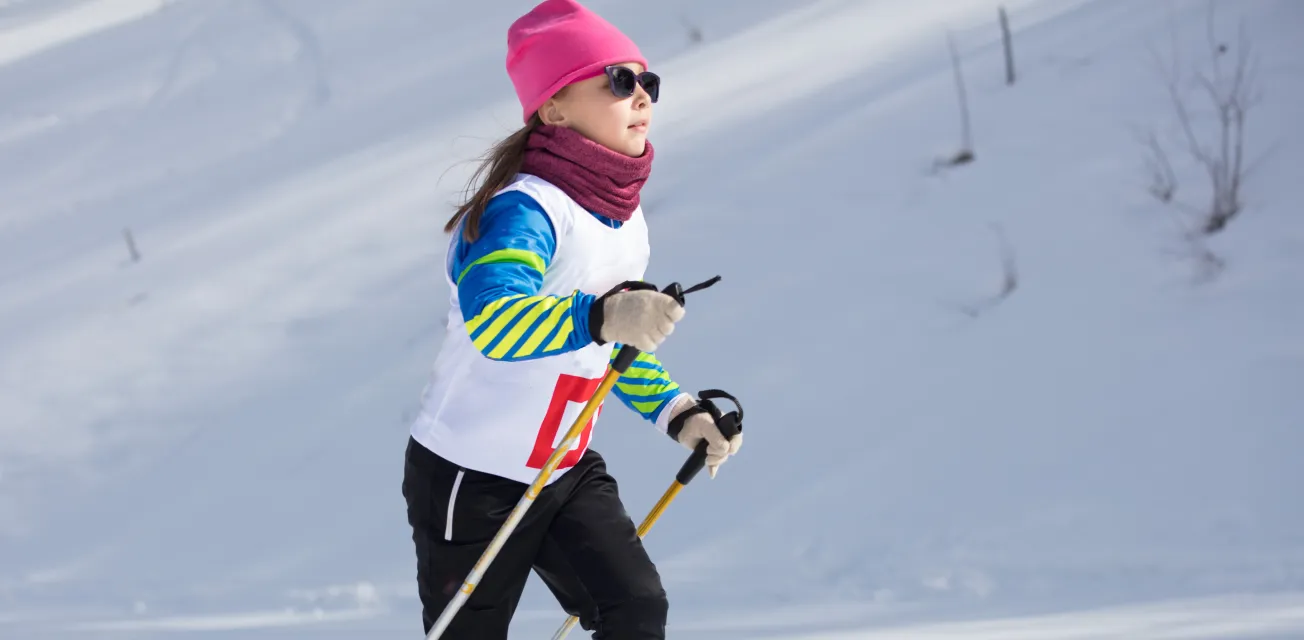 Flicka som deltar i skidtävling på längdskidor.