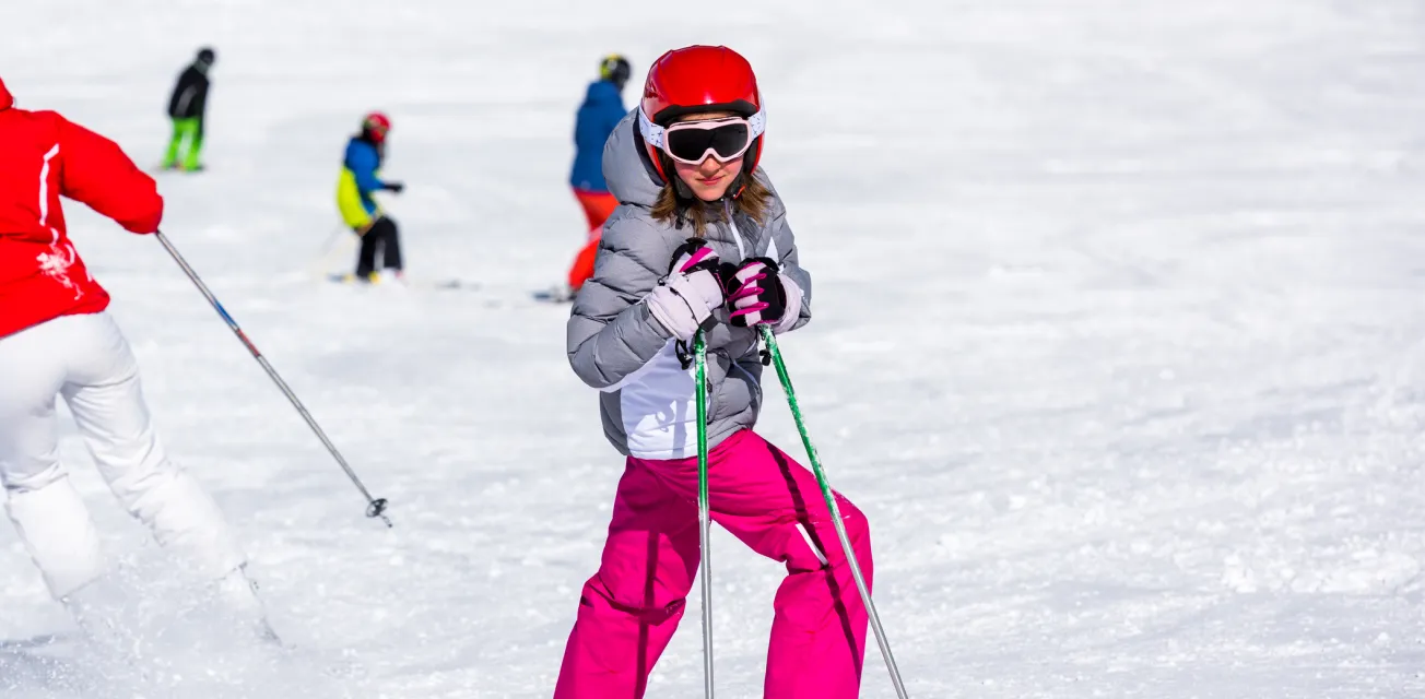 Flicka poserar i slalombacken. 