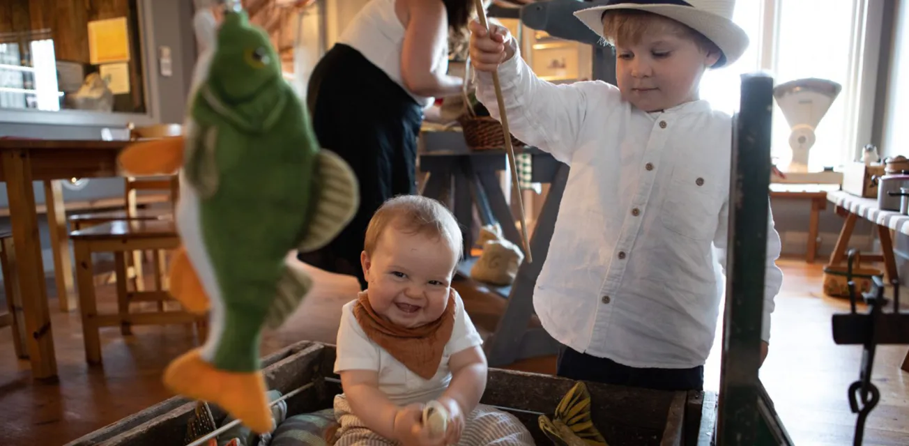 Barn som leker med leksaksfiskar i Ålands jakt- och fiskemuseum.