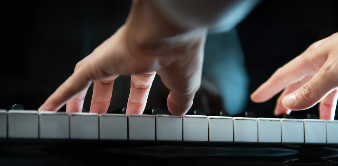 Händer som spelar på ett piano.