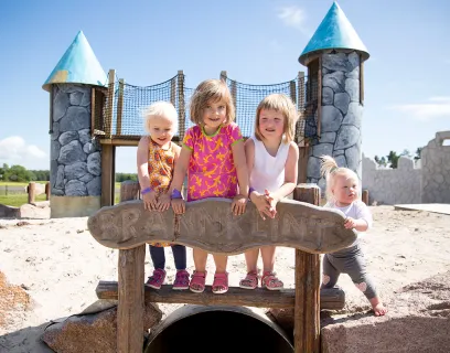 Barn poserar framför attraktion vid familjeparken Smart Park.