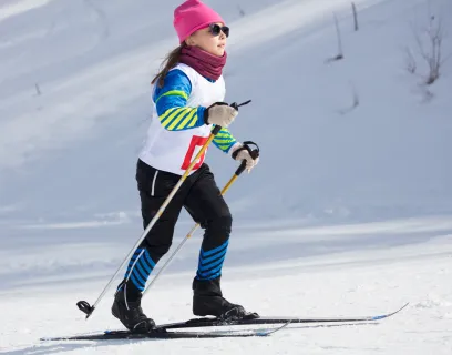 Flicka som deltar i skidtävling på längdskidor.