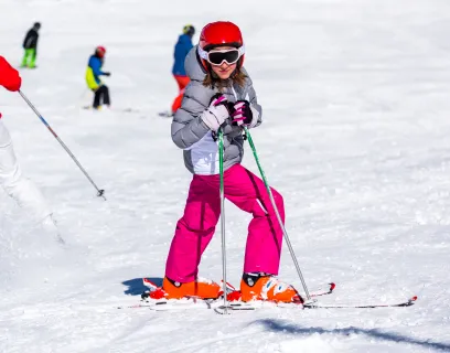 Flicka poserar i slalombacken. 